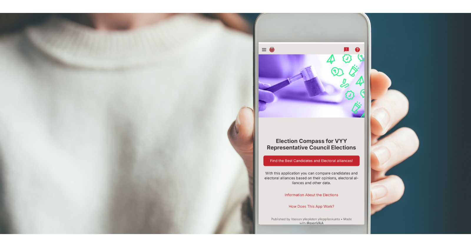 A close-up photograph of a hand holding a smart phone. On the screen is the front page to VYY's election compass.