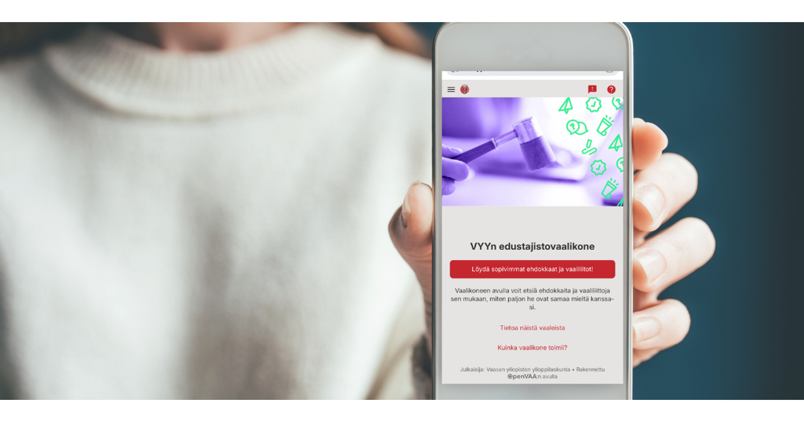 Valokuvassa lähikuva kädestä, joka pitää kameraa kohti älypuhelinta. Älypuhelimen näytöllä on auki VYY:n vaalikoneen etusivu.