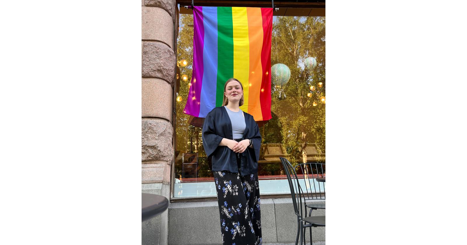 Man in front of Pride flag