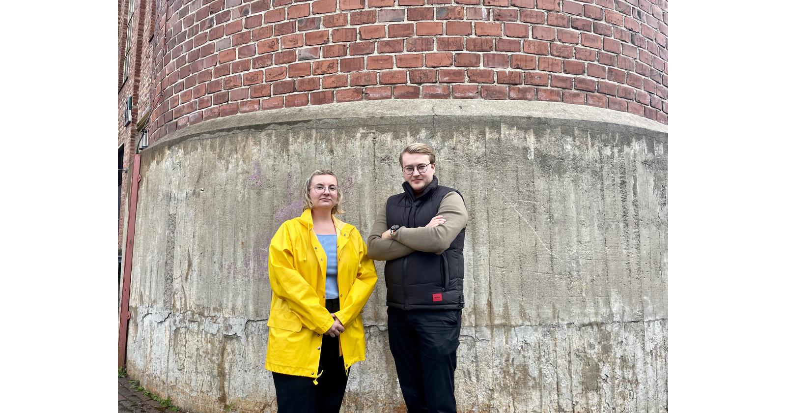 Kaksi ihmistä seinän edessä