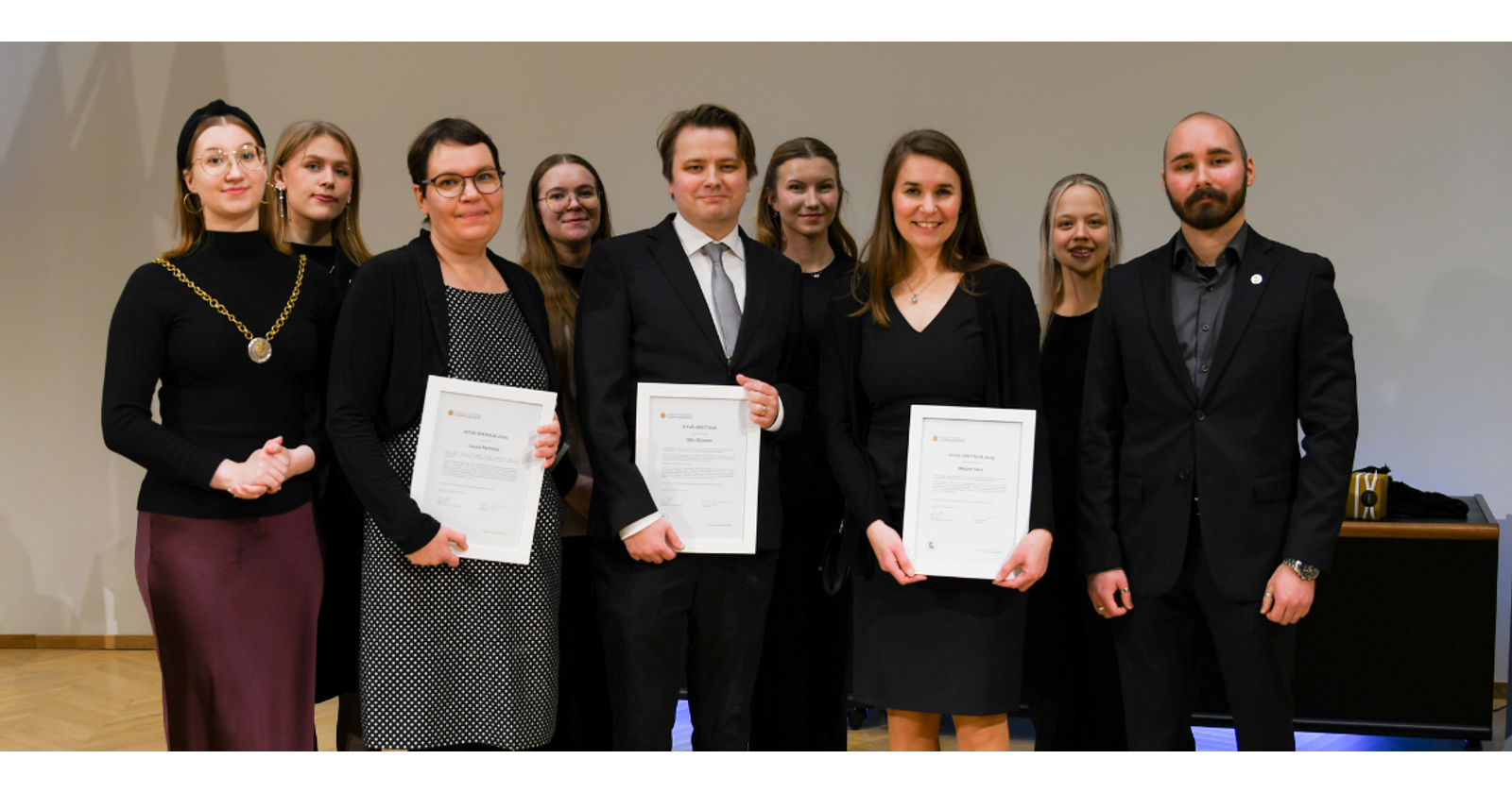 Valokuva VYY:n hallituksesta ja palkinnonsaajista hymyilem&auml;ss&auml; kameralle. Palkinnonsaajilla on kehystetyt palkinnot k&auml;siss&auml;&auml;n.