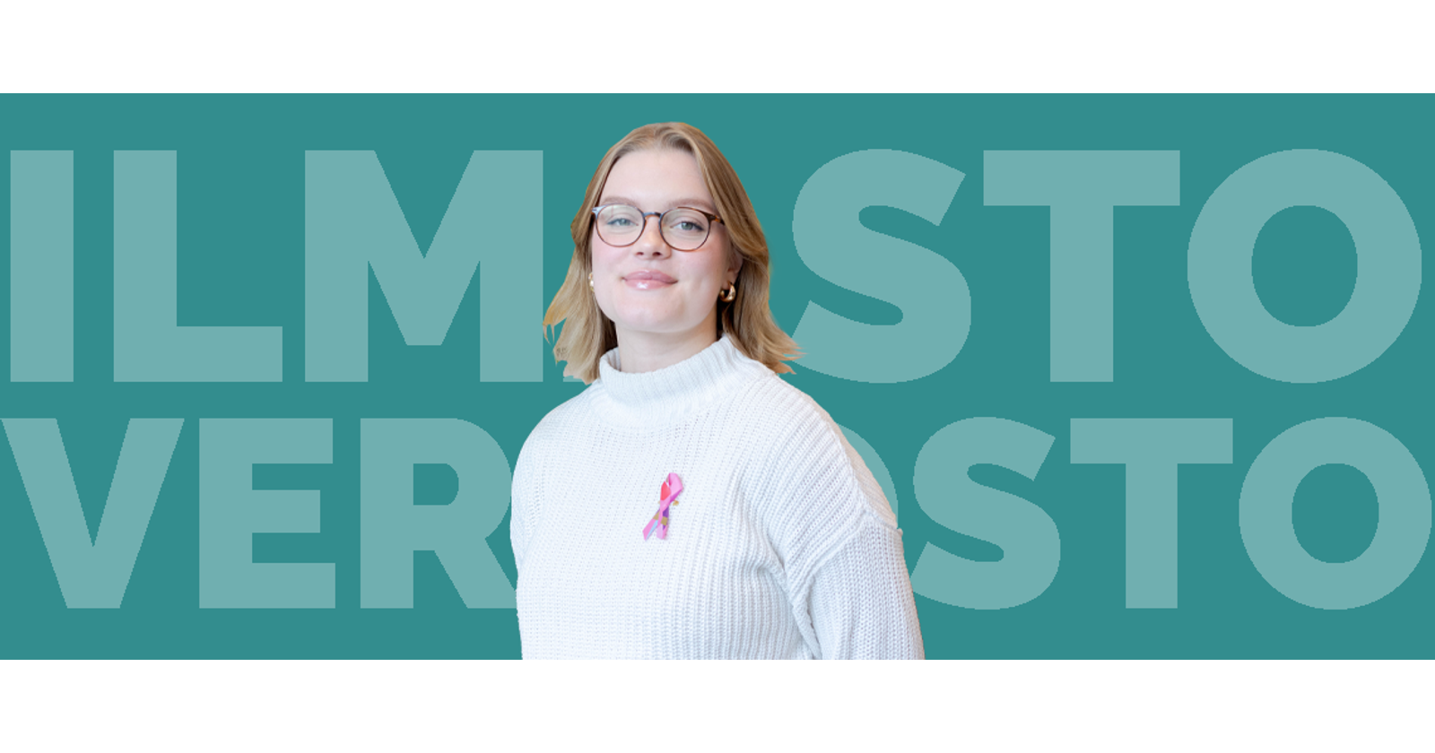 Laura seisomassa sinistä tausta vasten.