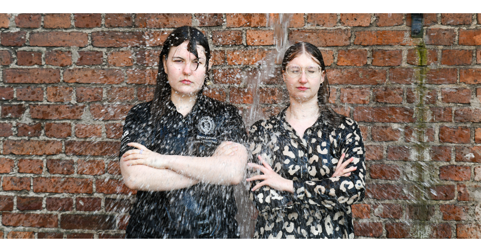 Valokuvassa Mimmi Eskelän ja Heidi Elersin päälle kaadetaan ylhäältä suuri määrä vettä.