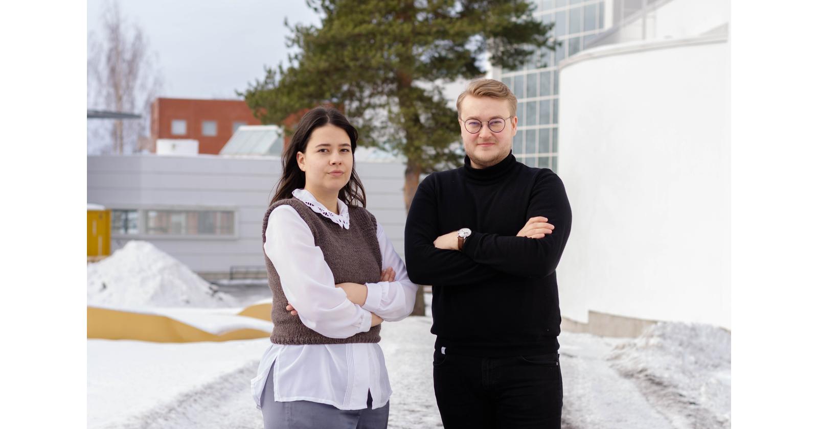 Sara ja Elmo seisomassa kampuksella kädet puuskassa katse kameraan päin.