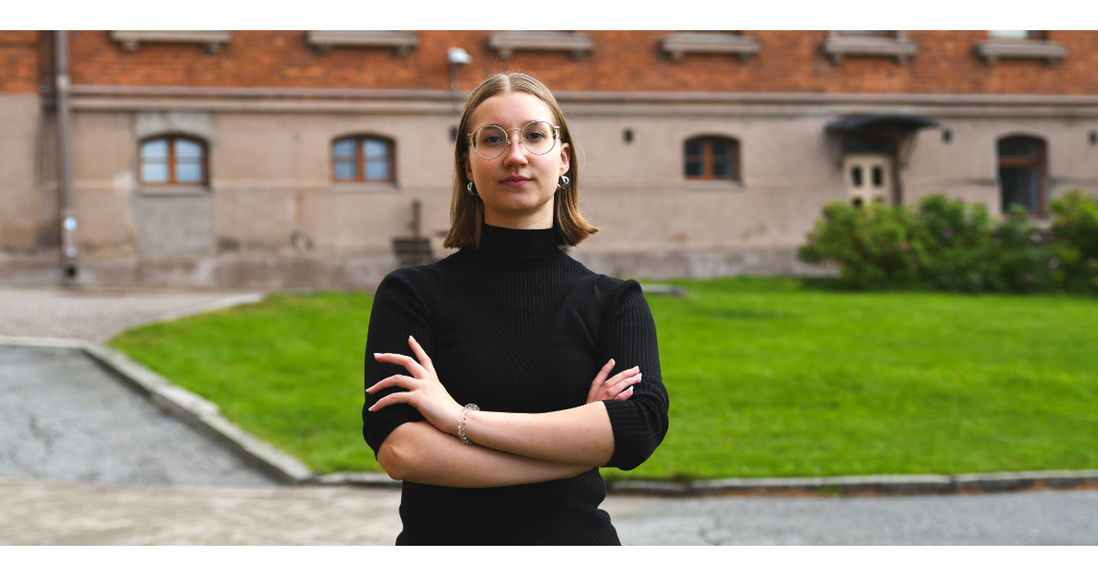 Photograph of Heidi Elers with arms crossed, standing in front of the Konttori building.