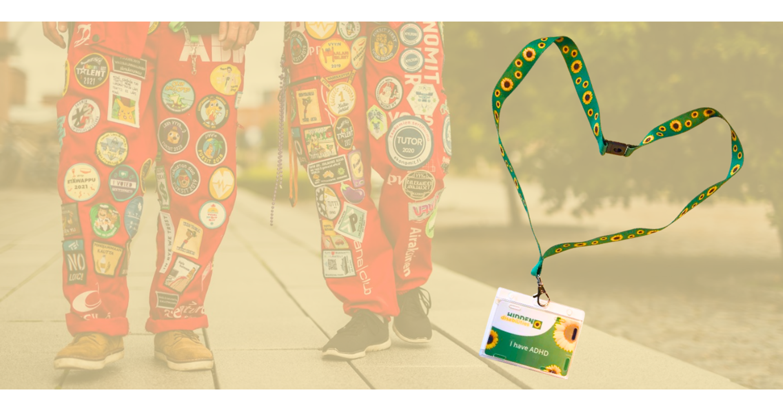 Grafiikassa taustalla valokuva kahden opiskelijan jaloista, joissa on opiskelijahaalarit. Kuvan p&auml;&auml;ll&auml; on valokuva auringonkukkakaulanauhasta, jossa on kyltti, jossa lukee "I have ADHD". 