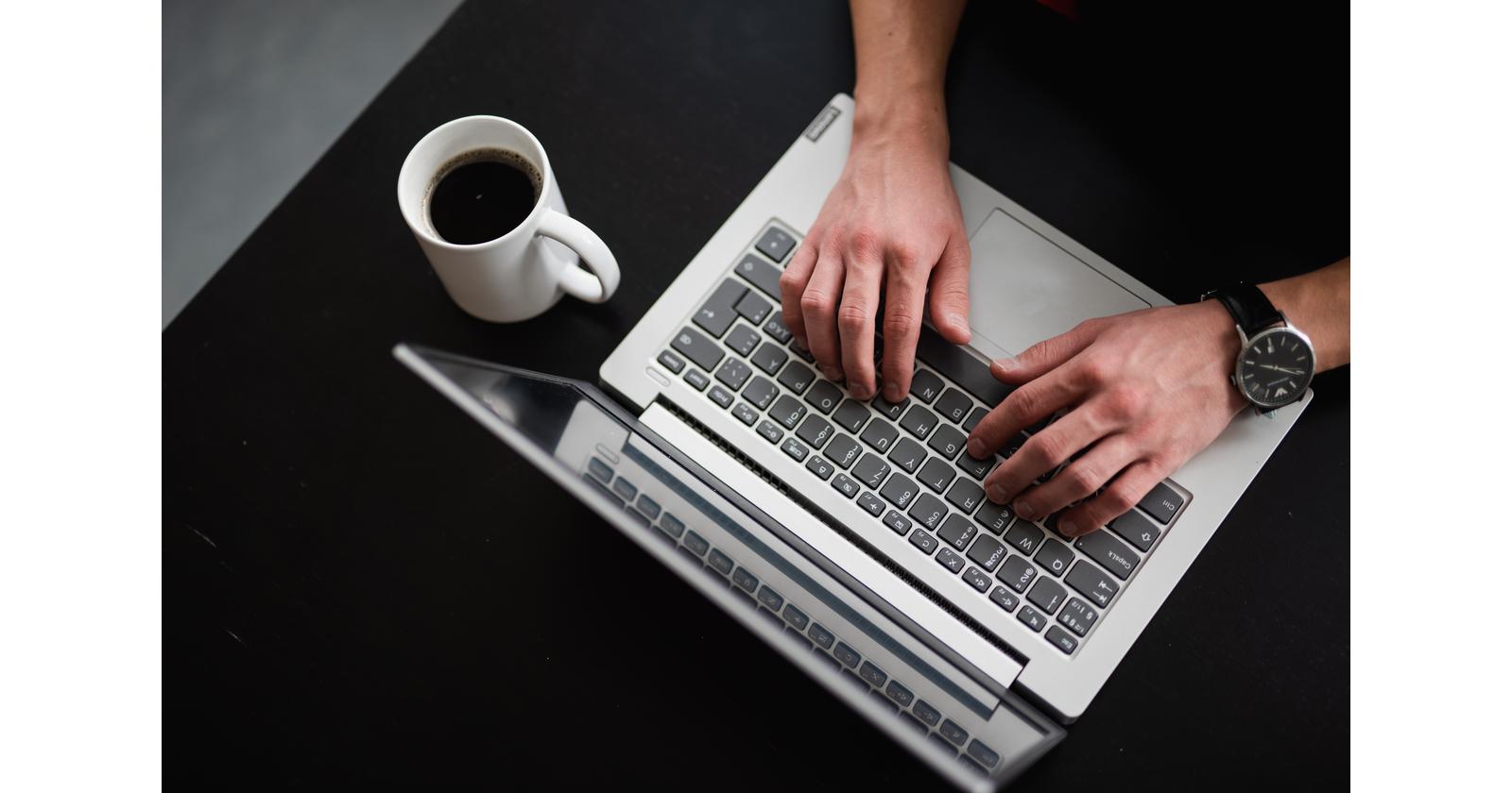 Hands typing on the keyboard of a laptop